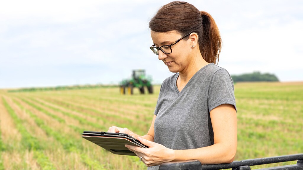 Image d'une femme tenant une tablette dans un champ