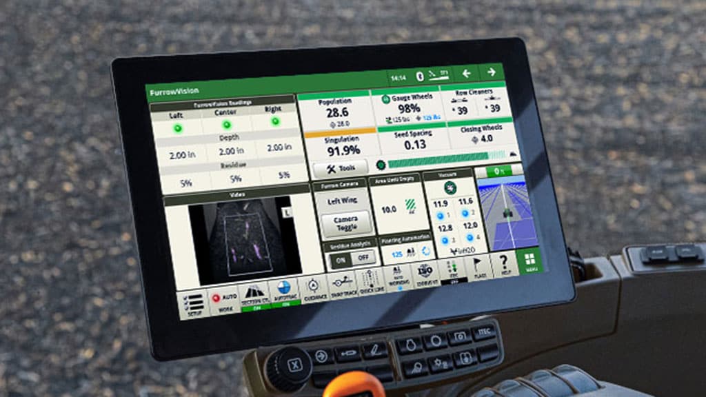 Console de la cabine du tracteur montrant l’interface FurrowVision John Deere avec des mesures d’ensemencement en direct et un flux de caméra pour sillons. Console de la cabine du tracteur montrant l’interface FurrowVision John Deere avec des mesures d’ensemencement en direct et un flux de caméra pour sillons.