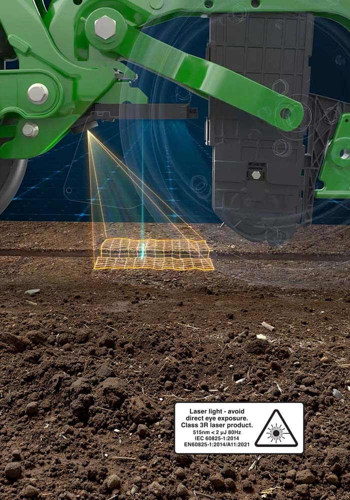 Élément à rangs de semoir de précision John Deere illustrée projetant un laser sur un sillon de sol, avec une incrustation de grille orange lumineux représentant la technologie de balayage FurrowVision.