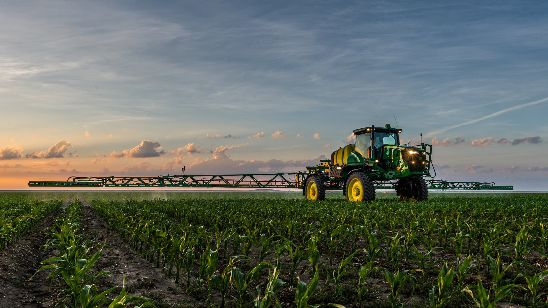 application à débit variable; photo d'un tracteur en train de pulvériser des produits dans un champ