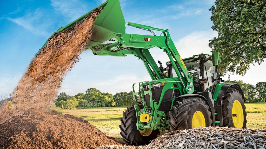 6 Series tractor using a front-end loader to dump out dirt.