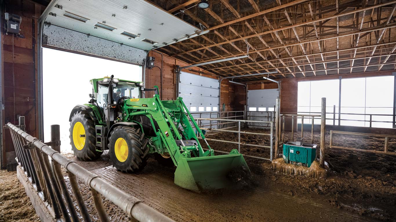 6R Tractor with a front-end loader in a barn.