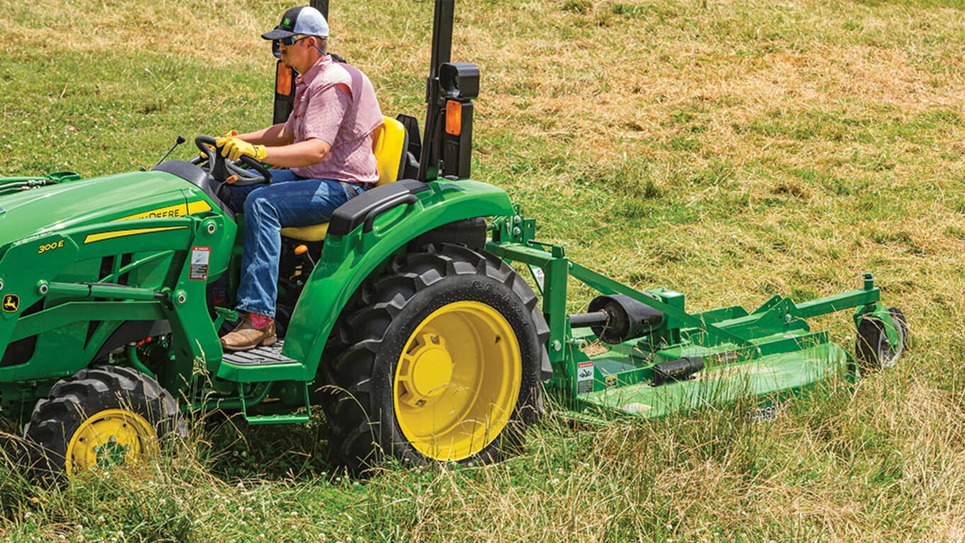 person mowing a field operating a 3043d