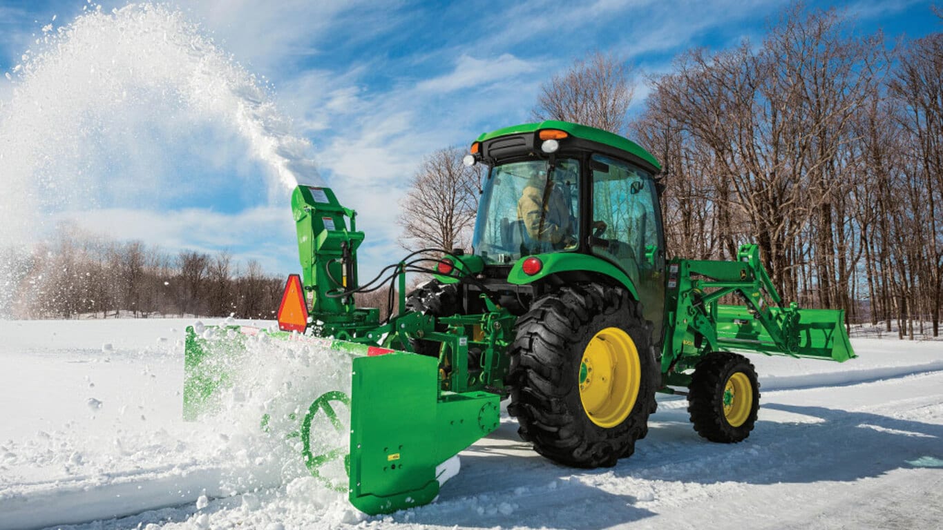 person operating a 4052r removing snow with a rear snowblower attachment