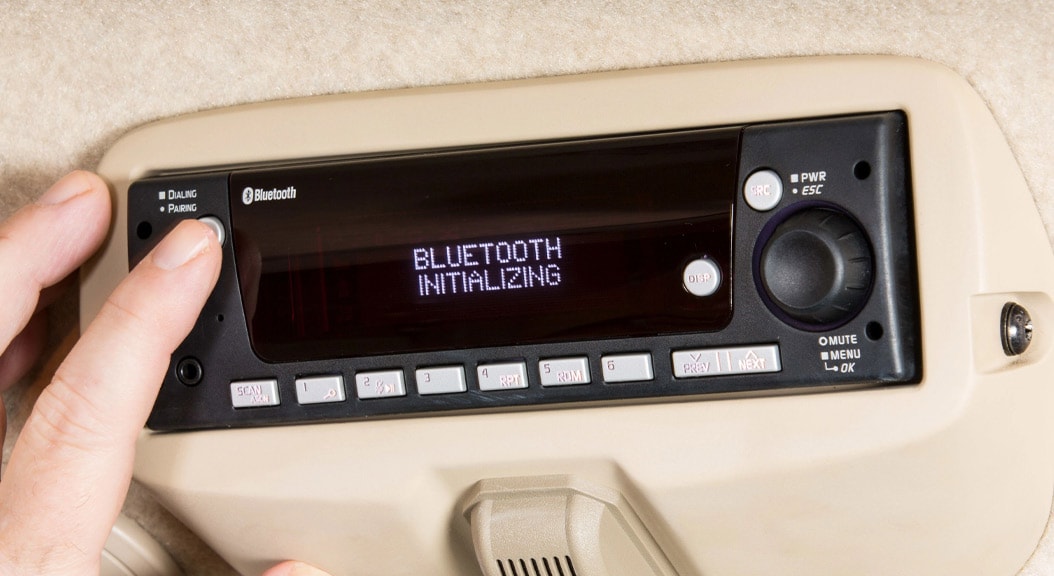 Close up of a person initialing the radio bluetooth function on the 4075R Compact Utility Tractor