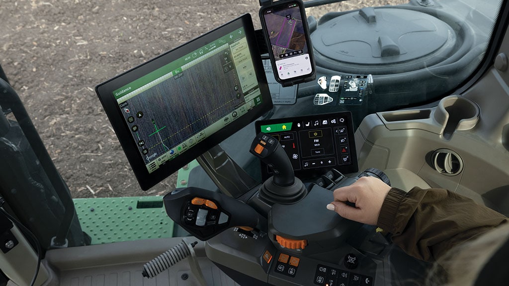 Vue de l’intérieur de l’environnement propre à l’expérience du conducteur John&nbsp;Deere présentant la console&nbsp;CommandARM™ et l’afficheur de commodité