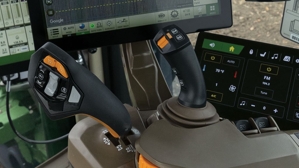 Gros plan sur les joysticks de commande de conduite dans la cabine d’un tracteur 8R