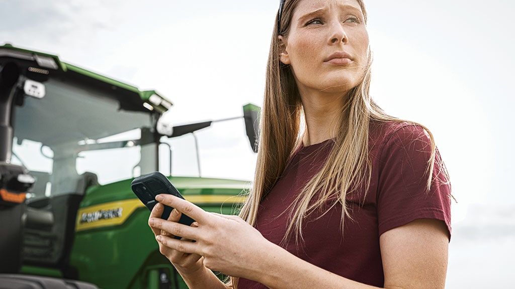 Personne utilisant la connectivité JDLink™ pour connecter son téléphone au John Deere Operations Center™