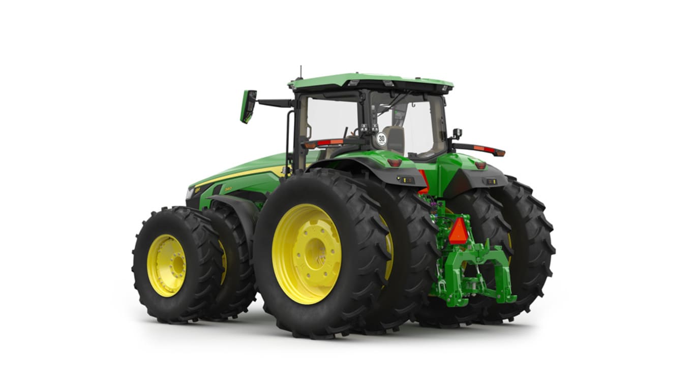 Rear-left-facing studio shot of a 16-wheeled green tractor on a white background.