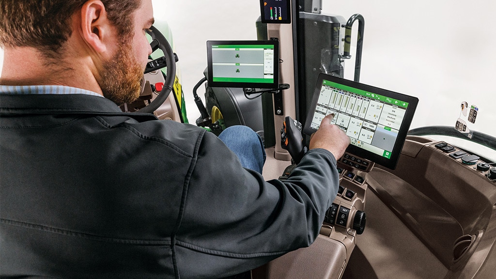 Homme interagissant avec un afficheur G5 dans la cabine d’un tracteur