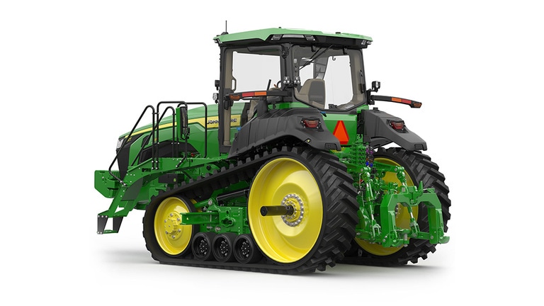 Rear-left-facing studio shot of a 2-tracked green tractor on a white background.