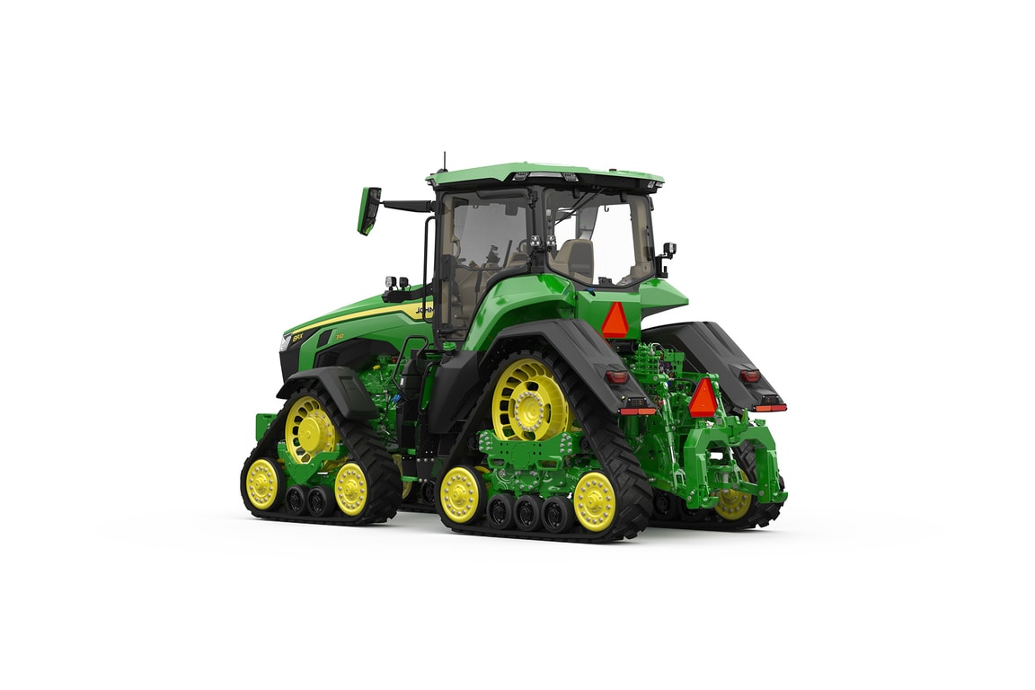 Rear-left-facing studio shot of a 4-tracked green tractor on a white background.