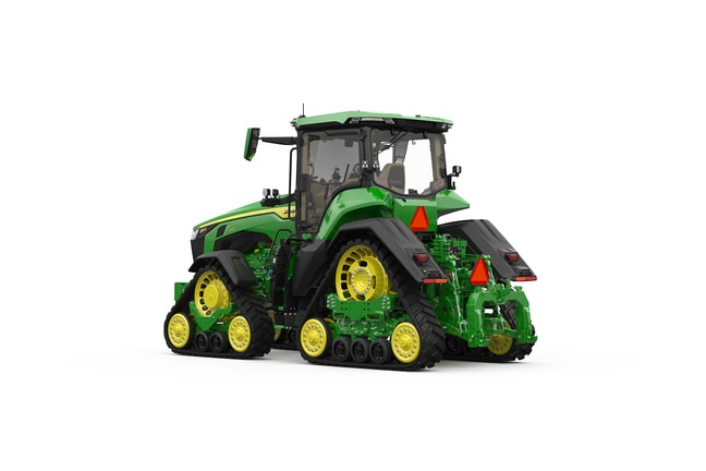 Rear-left-facing studio shot of a 4-tracked green tractor on a white background.