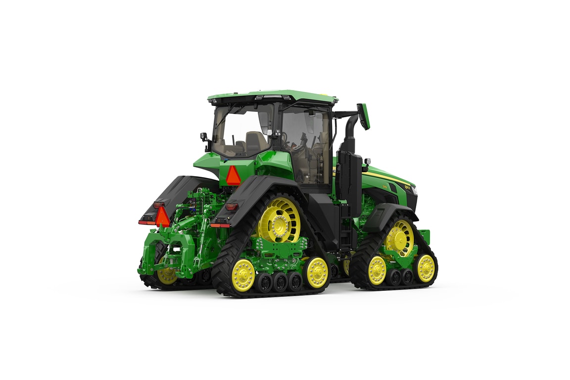 Rear-right-facing studio shot of a 4-tracked green tractor on a white background.