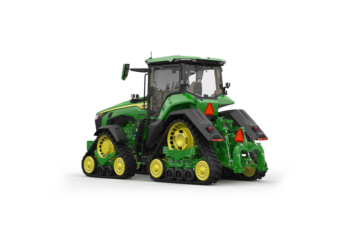 Image studio d'un tracteur vert à&nbsp;4&nbsp;chenilles vu de l'arrière gauche sur fond blanc.