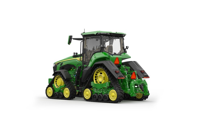 Image studio d'un tracteur vert à&nbsp;4&nbsp;chenilles vu de l'arrière gauche sur fond blanc.