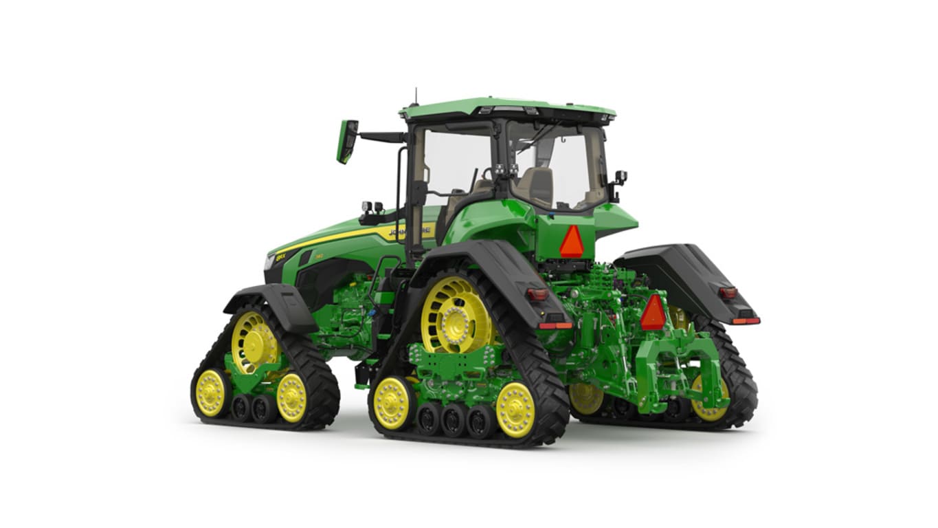 Image studio d'un tracteur vert à&nbsp;4&nbsp;chenilles vu de l'arrière gauche sur fond blanc.