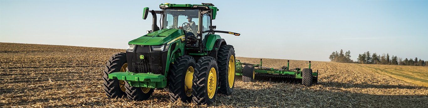 Un tracteur de la série 8R de grande puissance labourant un champ.