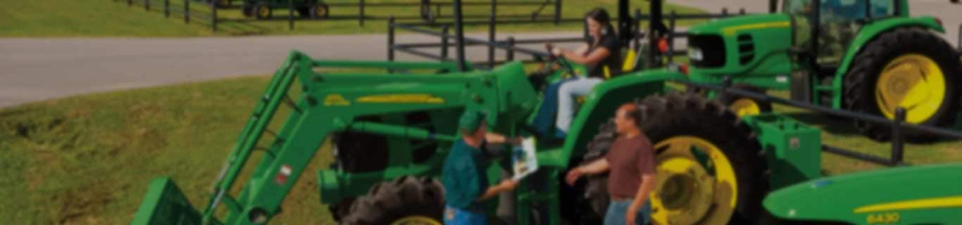 dealership image with woman testing tractor