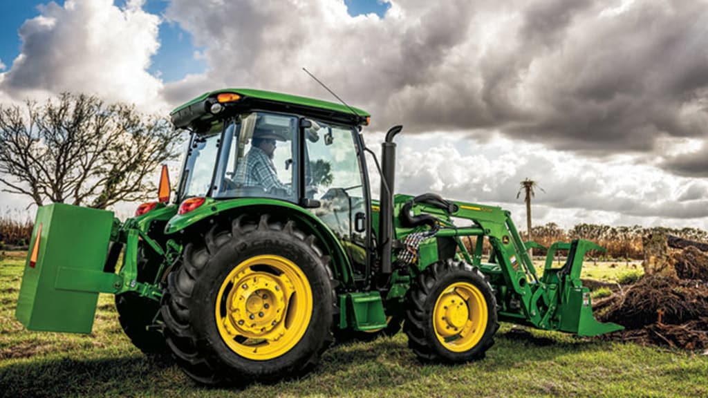 fermier conduisant un tracteur 5E avec chargeur frontal dans un champ