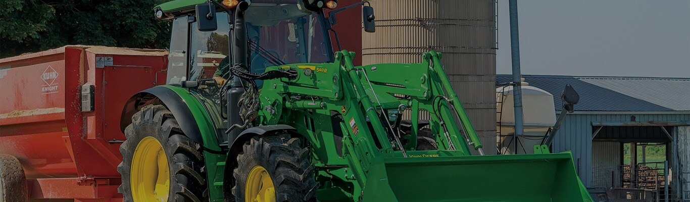 Image d'un tracteur 5125R devant une grange