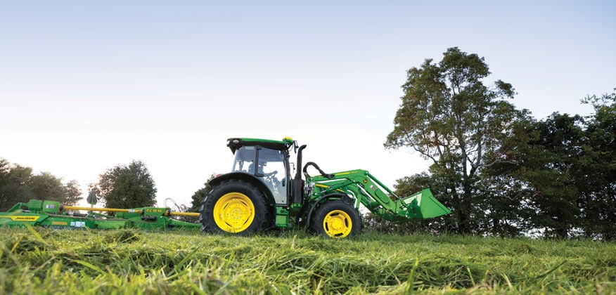 tracteur 5M fauchant l’herbe dans un champ