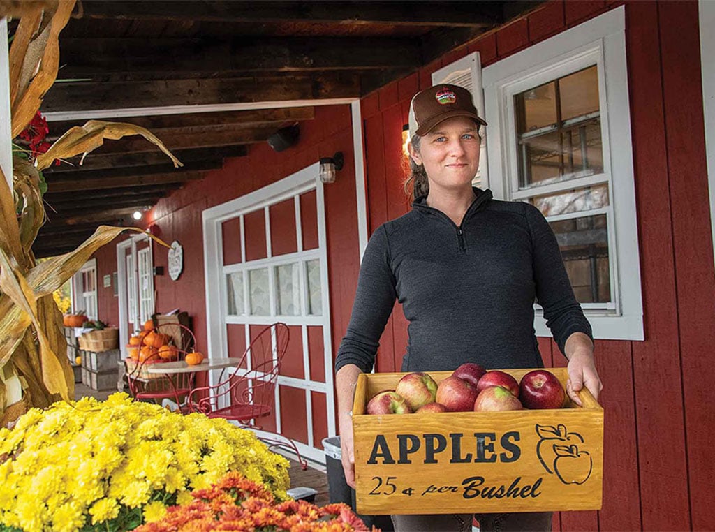 female holding box of apples