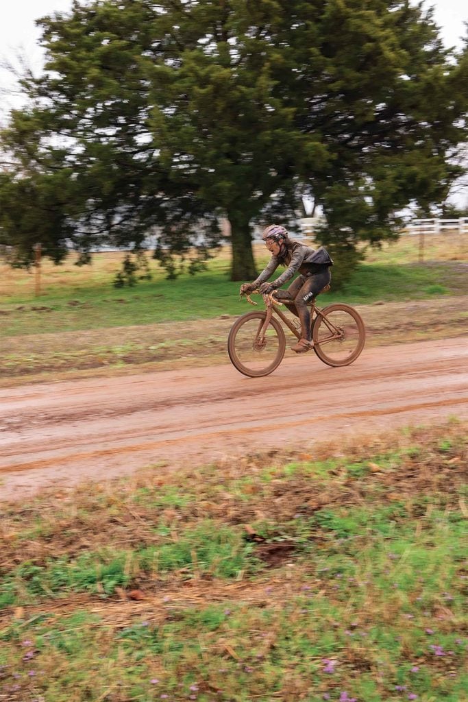 Cyclist on muddy gravel road