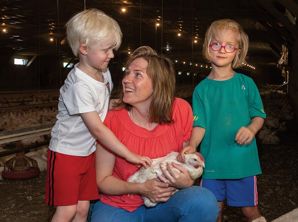 mom with two children holding a chicken