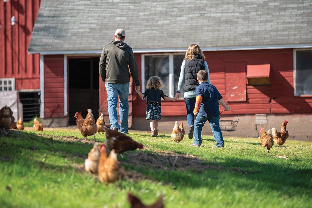 family in front of barn with chickens