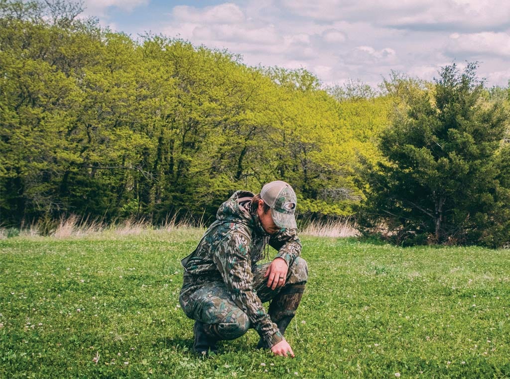 Man pulling weeds with his hands