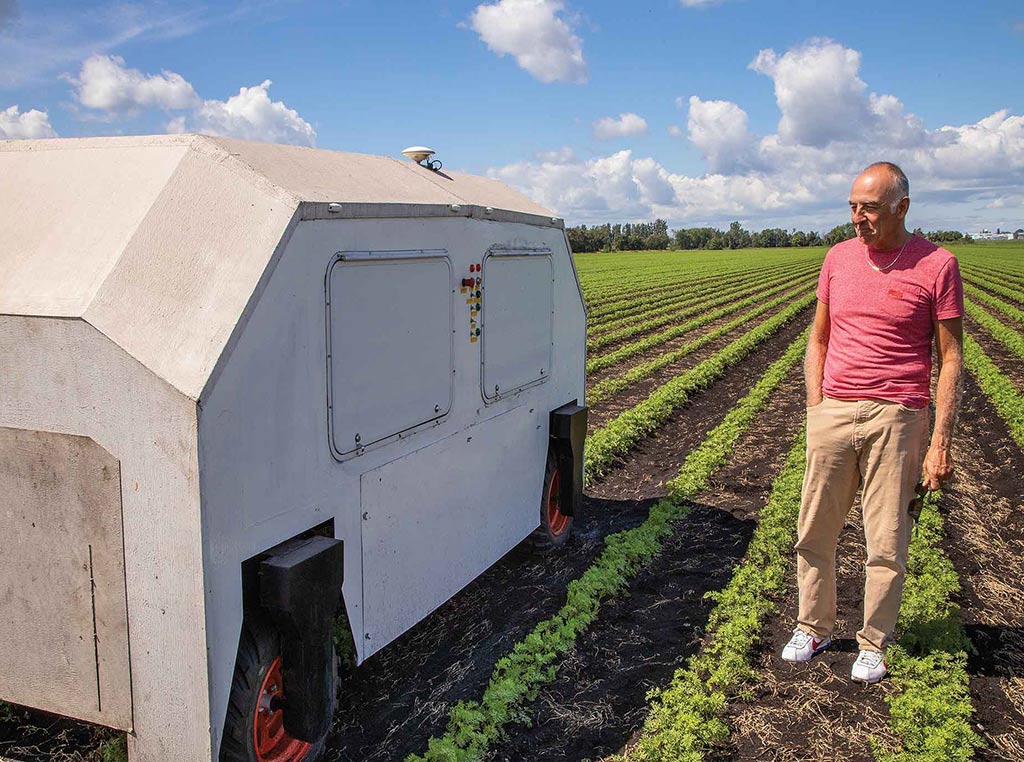 Man standing with robot in field