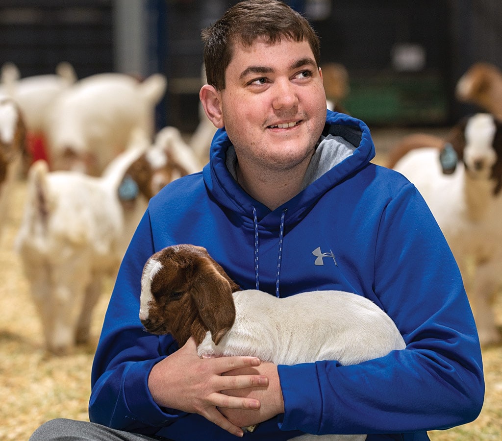 a boy holding a goat