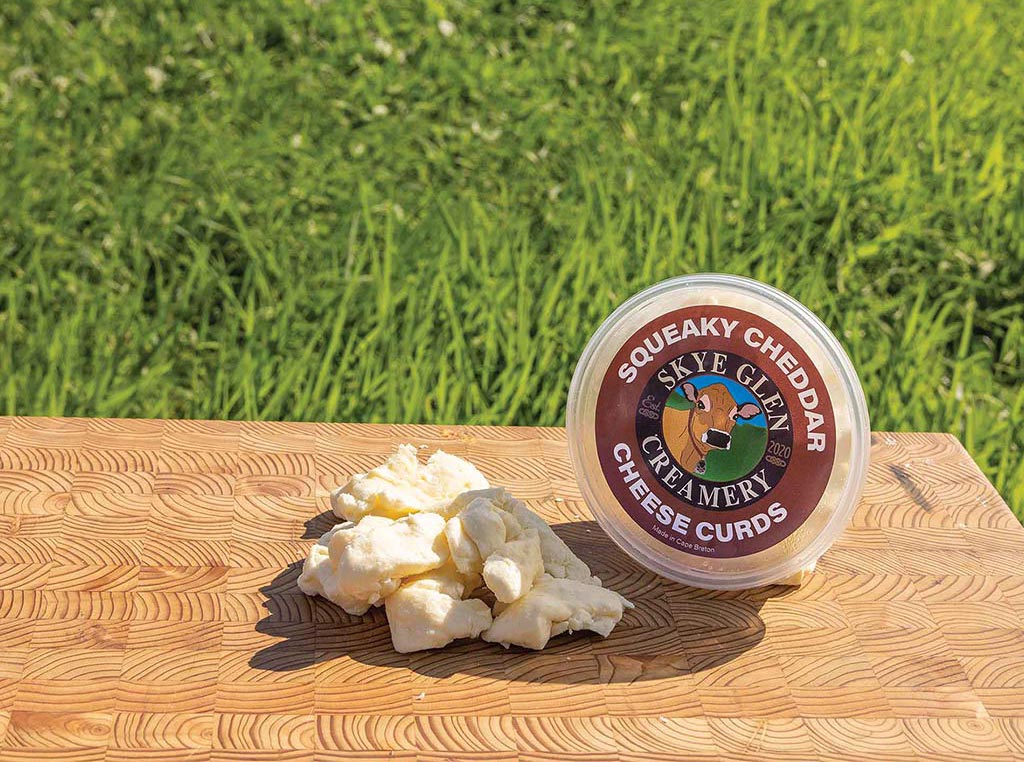 container of cheese curds on wooden table outside