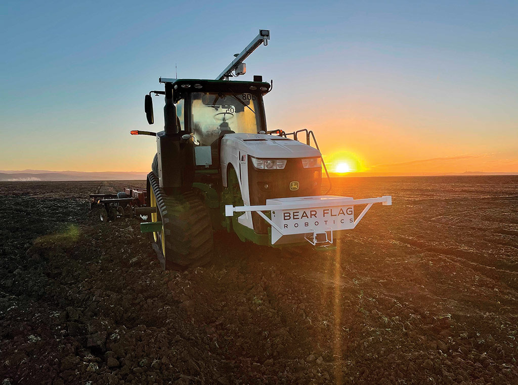 tracteur dans le champ au coucher du soleil