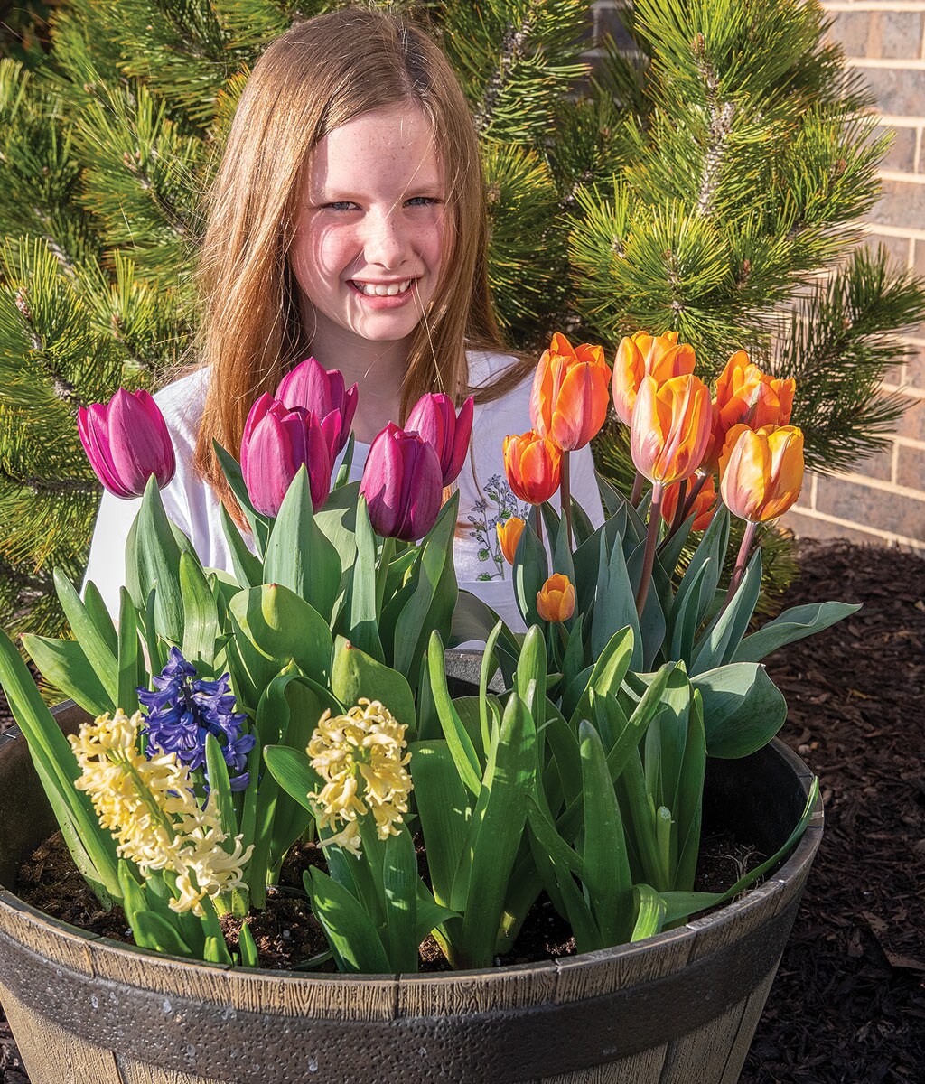 Jocelyn Stevenson enjoys the blooms from tulips and hyacinths in a container of fall-planted bulbs.