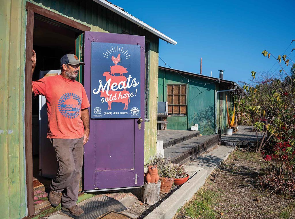 man standing in doorway of meat shop