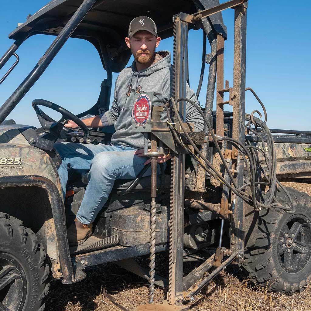 farmer drilling for soil core samples