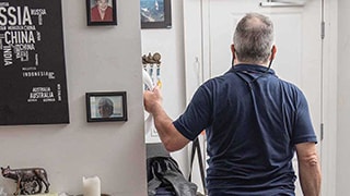 man facing door in home holding onto handle attached to wall