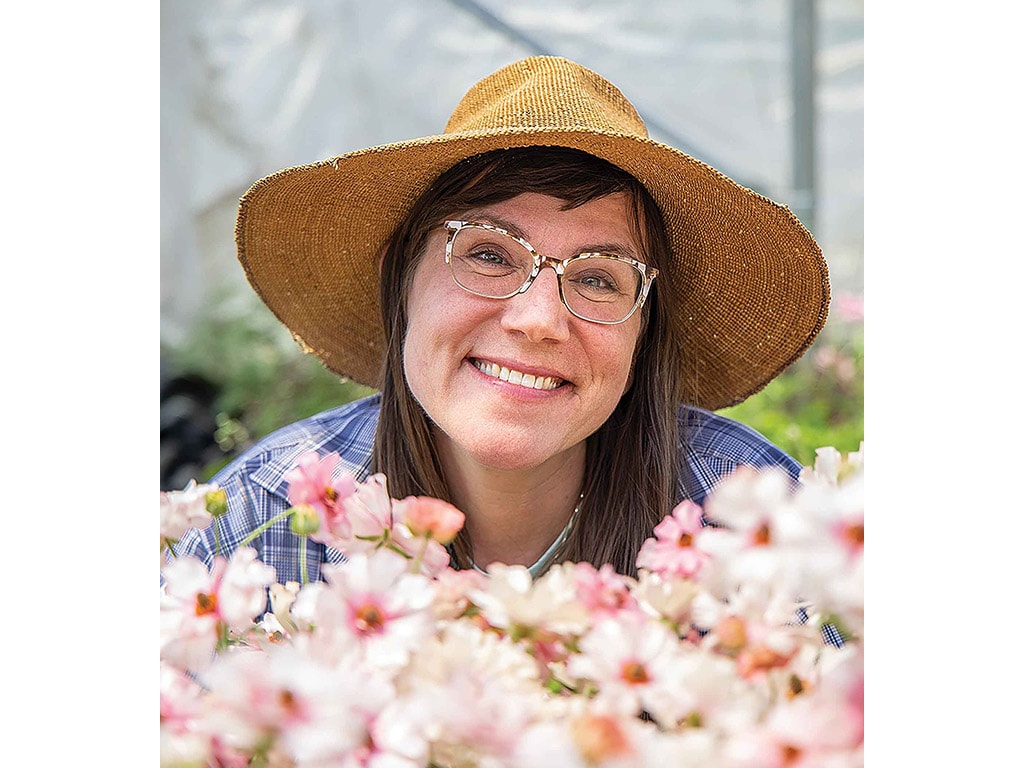 Miranda Duschack smiles while looking at butterfly ranunculus