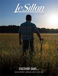 person standing in field with hand resting on shovel