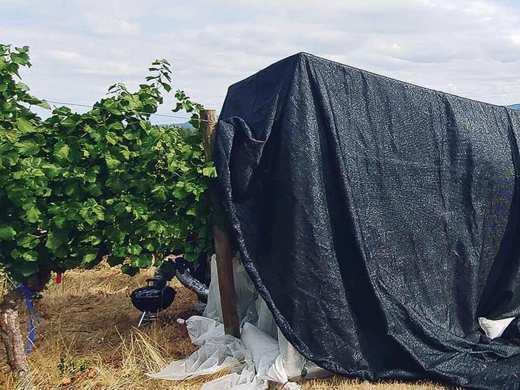 a grill covered by a large black tarp