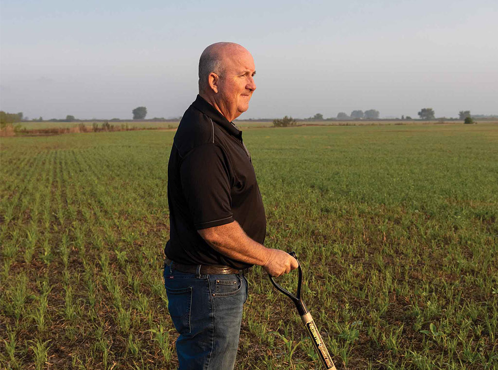 man standing with shovel in field