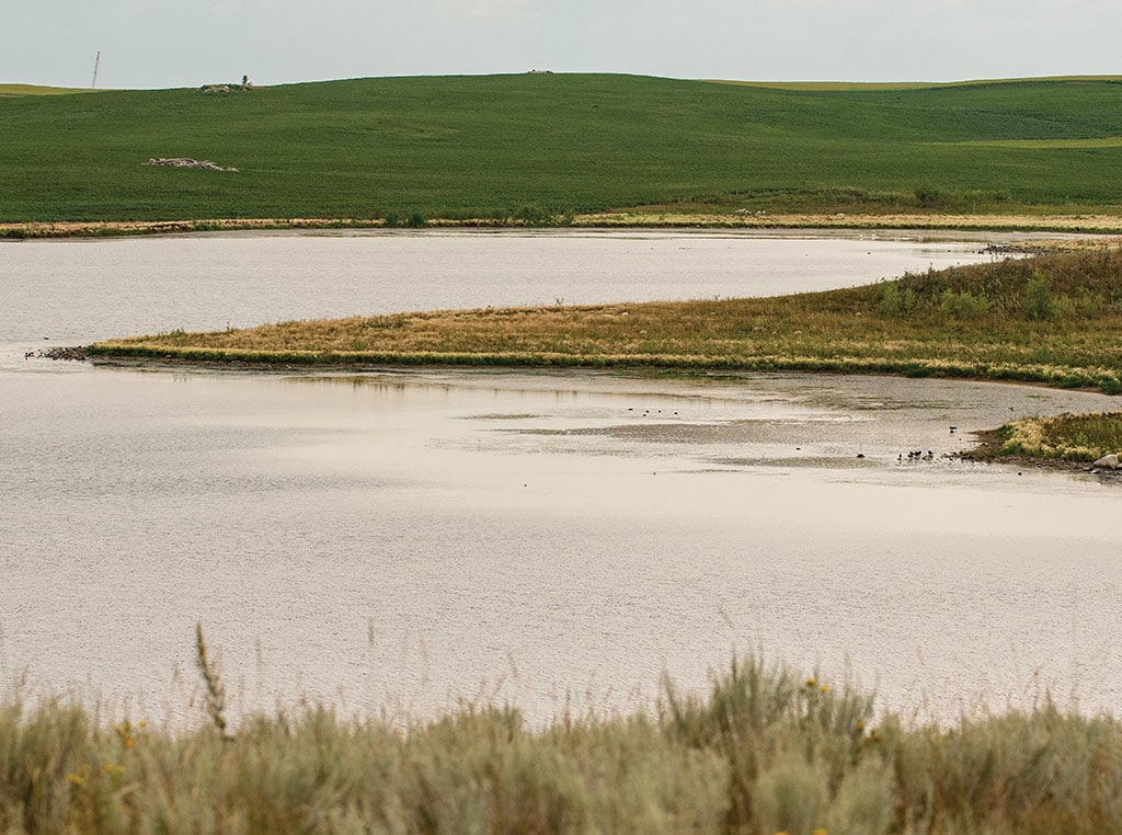 large pond with sections of fields in the distance