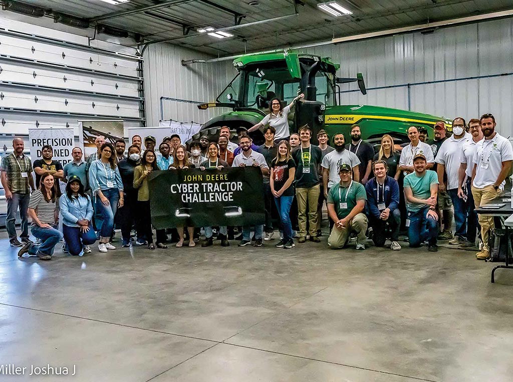 group of people lined up in front of Deere tractor