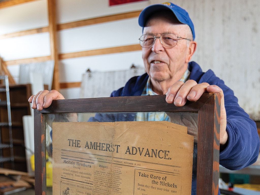 Person holding a framed newspaper article