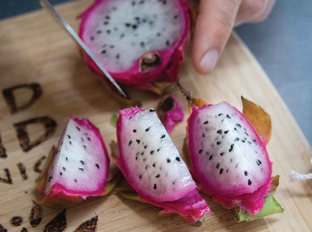closeup of sliced dragonfruit wedges on wood cutting board