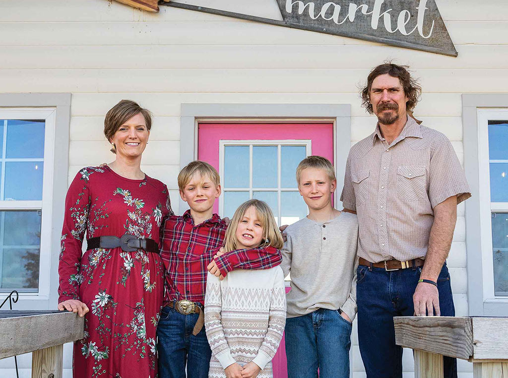 family of five standing at storefront with wood handrails