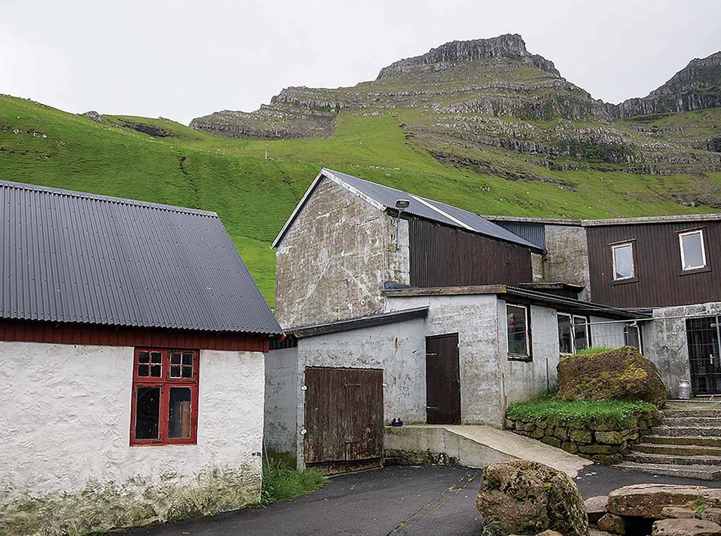 small white homes with towering hill behind