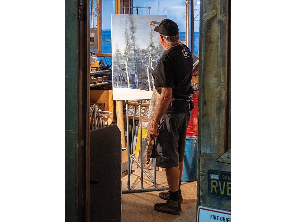 person painting on a canvas in a room